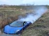 Sportauto schiet uit de bocht en belandt met rokende motor in het water